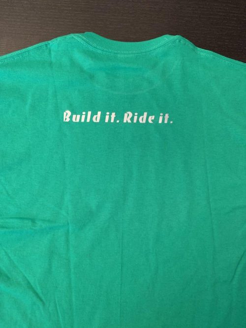 A green shirt that says build it. Ride it