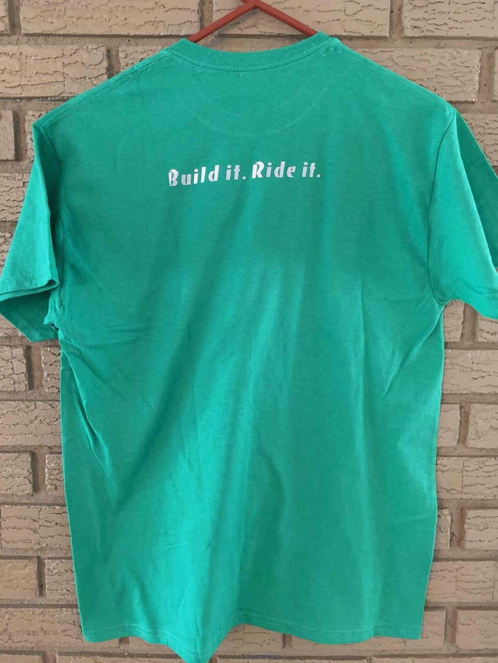 A green shirt that says " build is more. It."