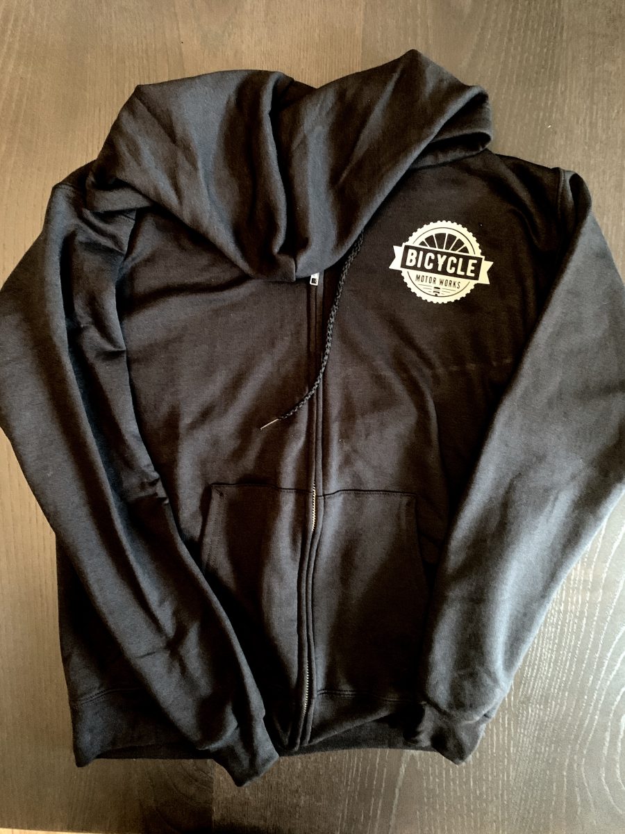 A black zip up hoodie with the words " kush " on it.
