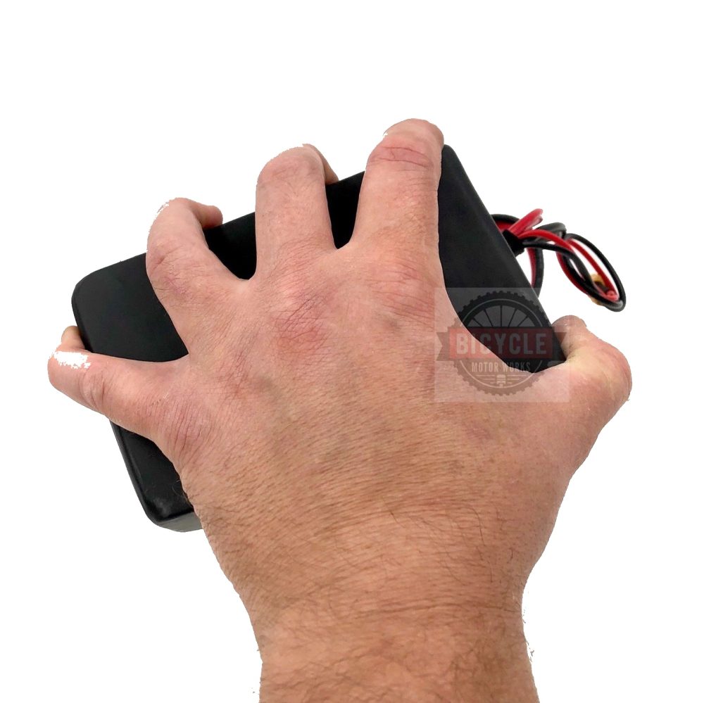 A hand holding a remote control in one hand.