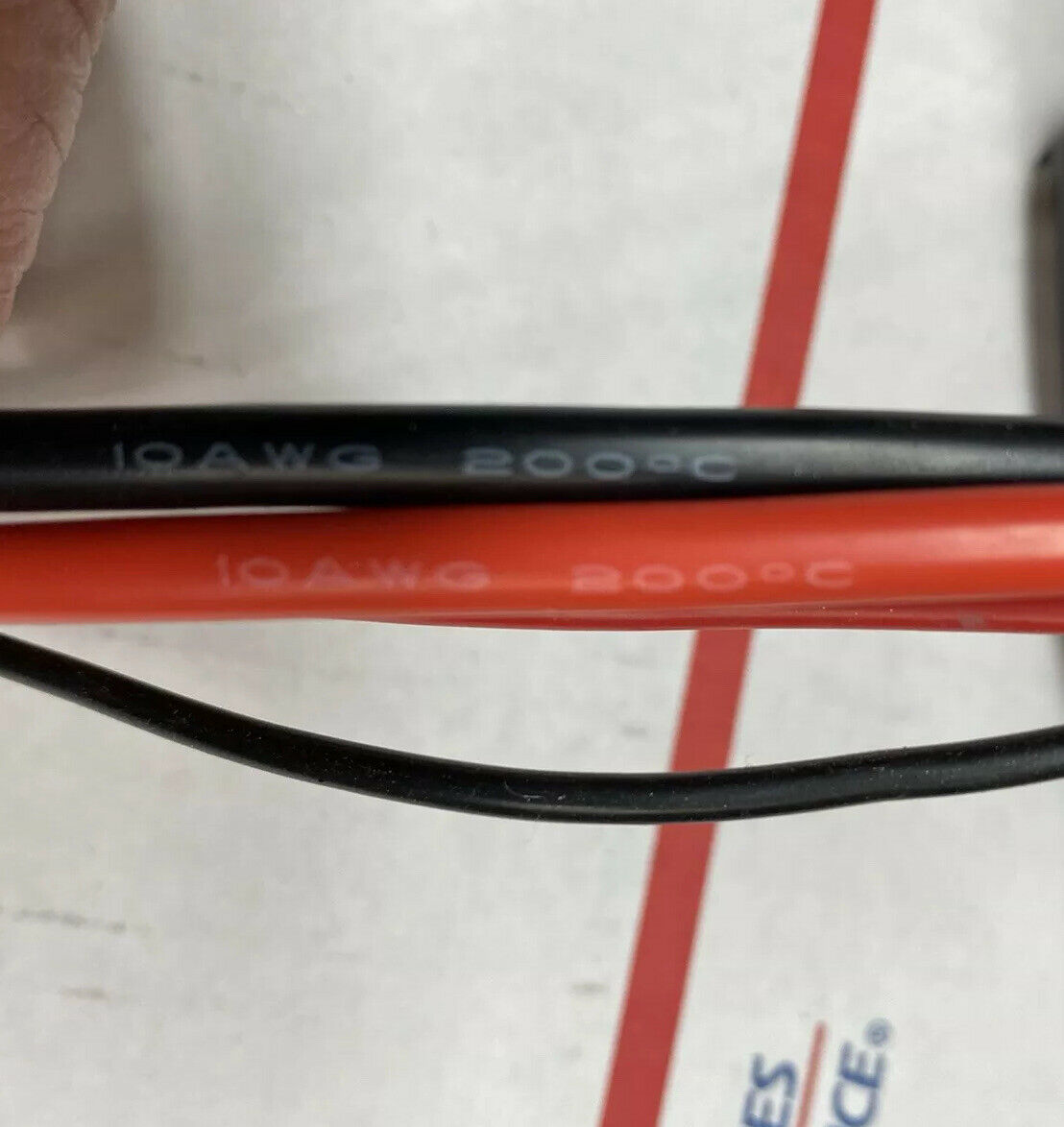 A pair of black and red cables sitting on top of a floor.