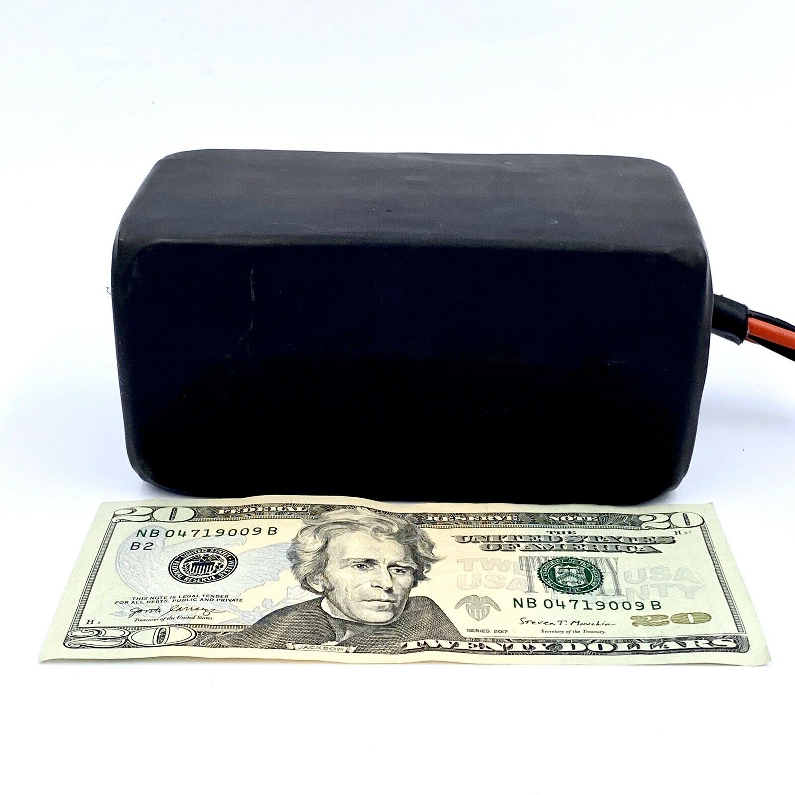 A black box with a dollar bill on top of it