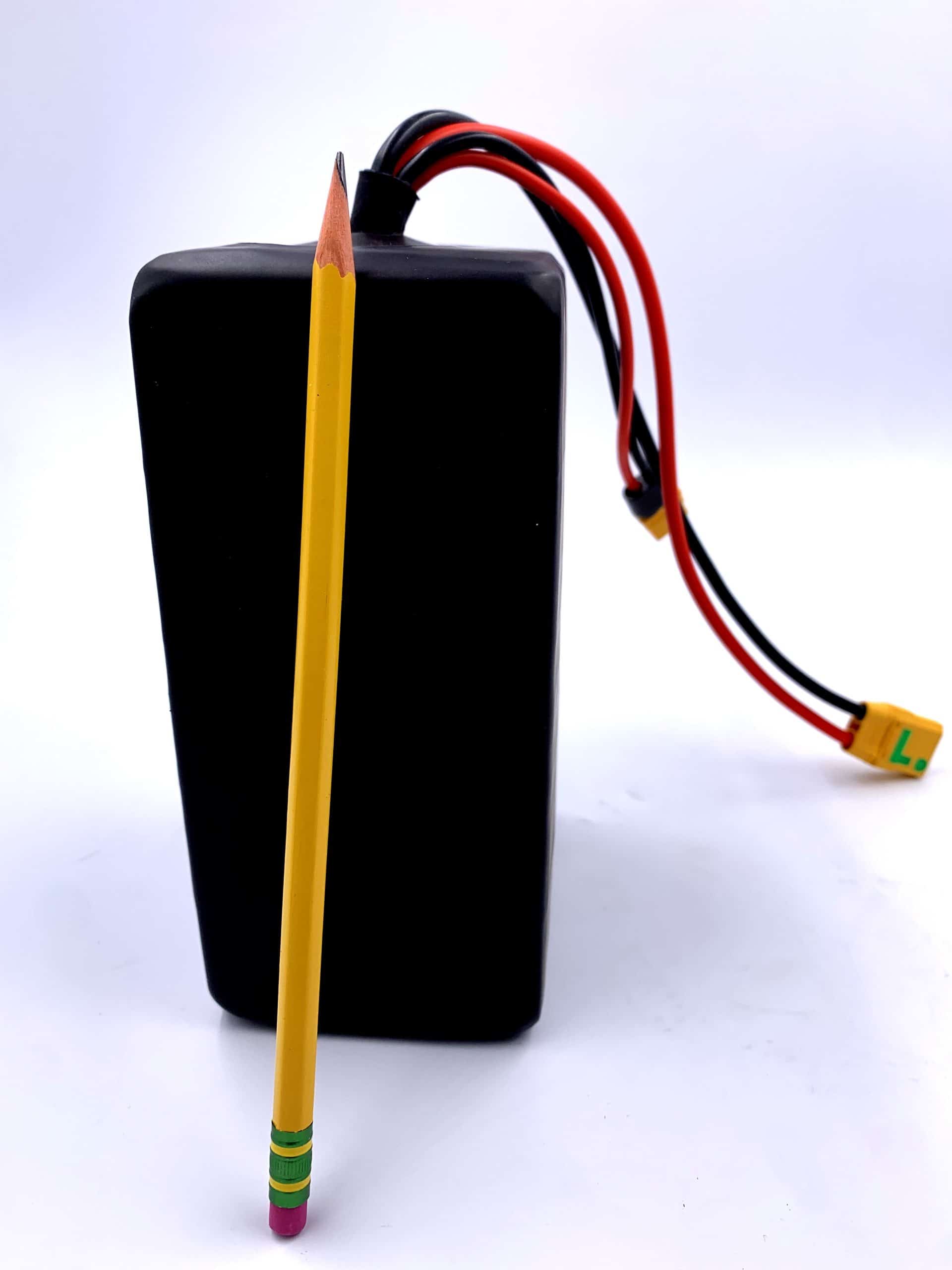 A yellow pencil is next to an electric device.